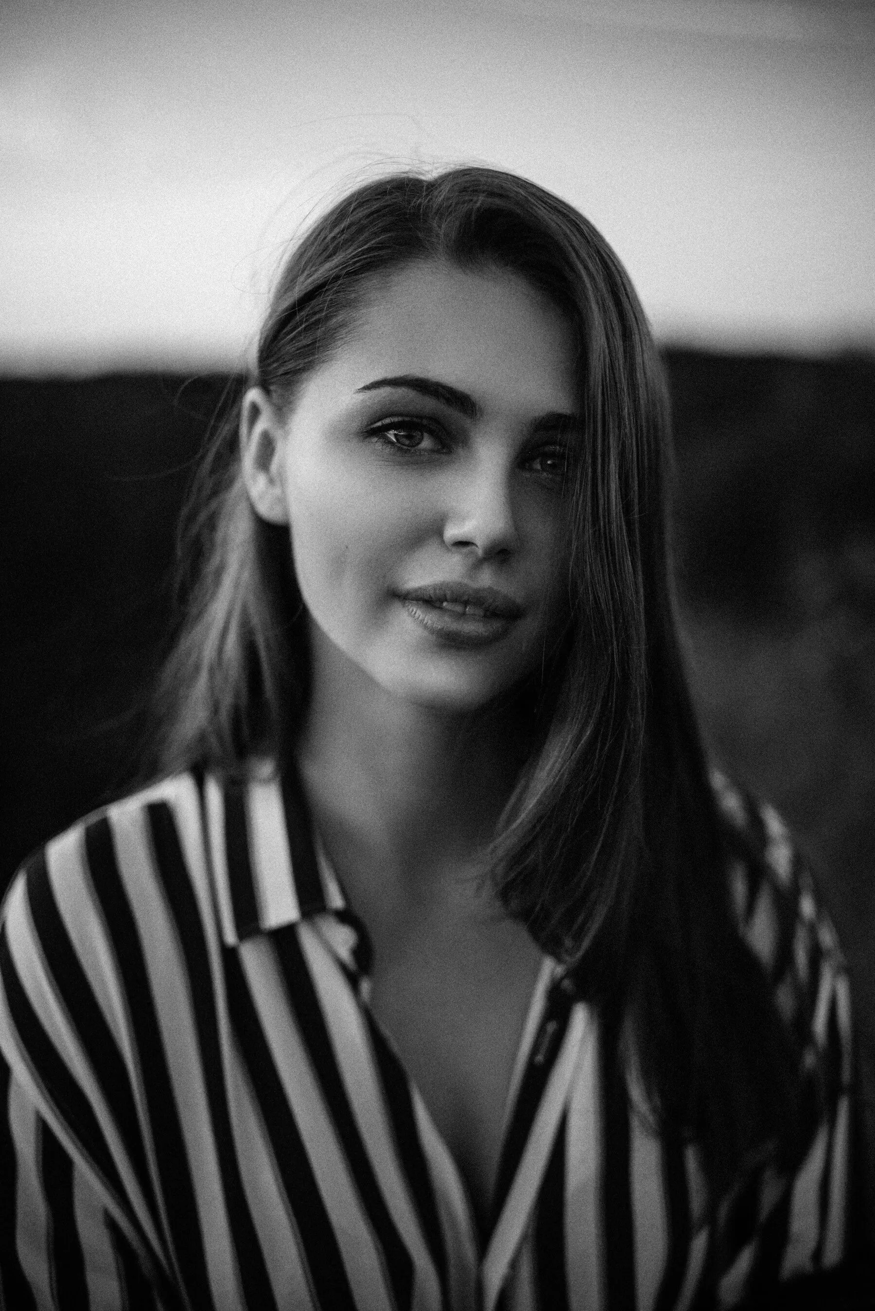 Portrait of a woman in a striped shirt at dusk