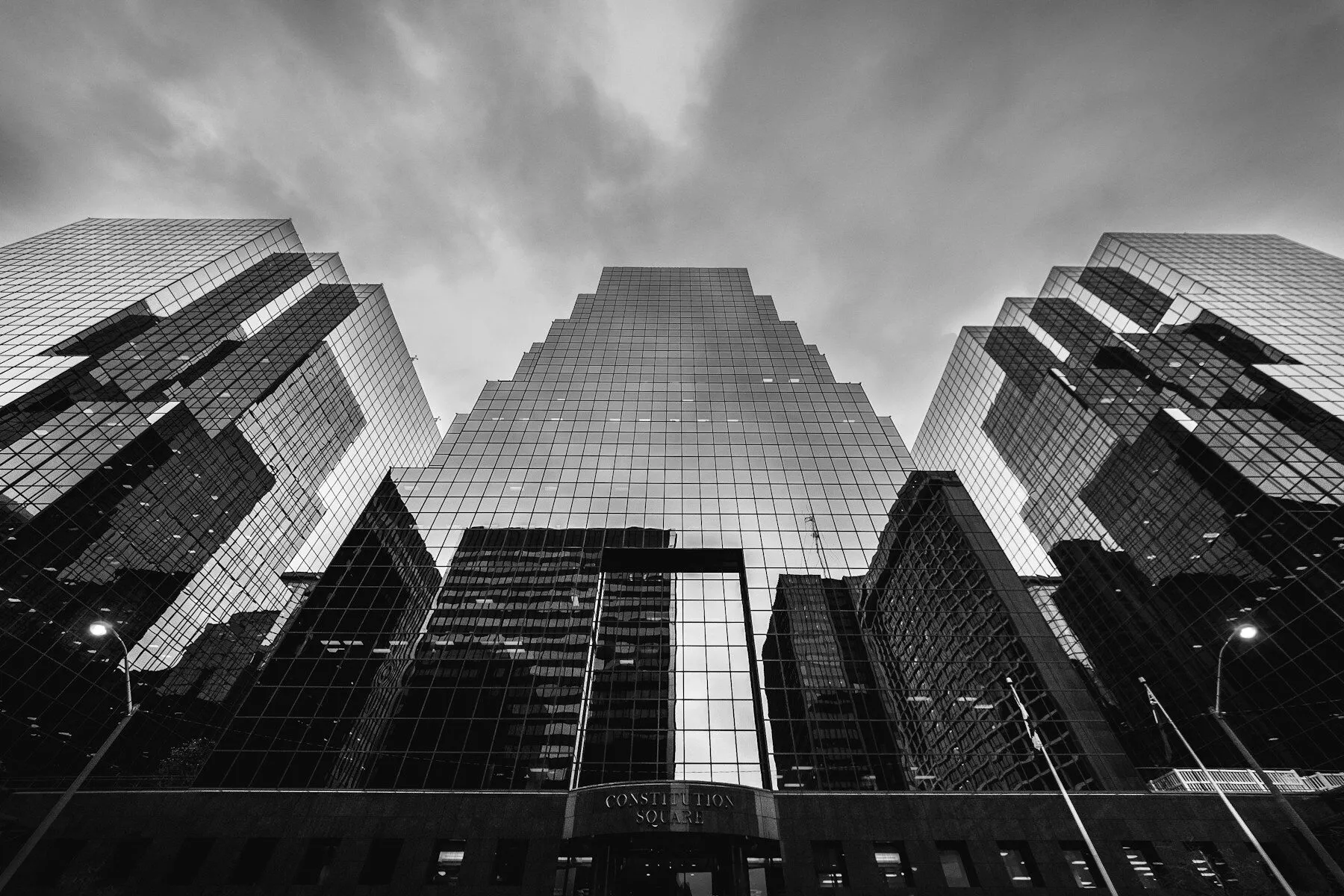 Glass towers seen from below under heavy cloud